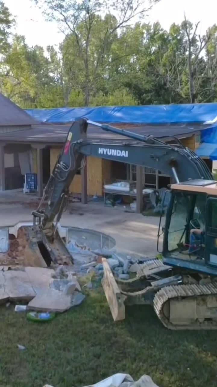 Excavator breaking up a swimming pool